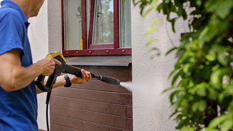 Power washing the side walls and accent trims of a residential building to remove algae deposits, and keep the appearance of the building clean.